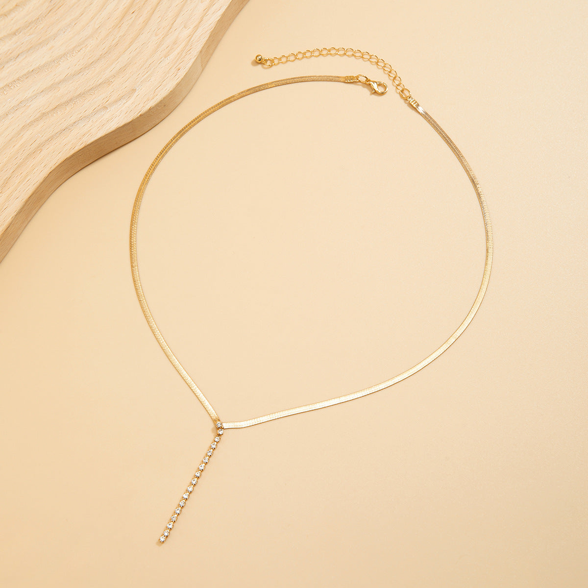 Gold-tone Snake Bone Y-Drop Crystal Tassel Necklace featuring a sleek design with crystal accents and a unique snake bone detail.