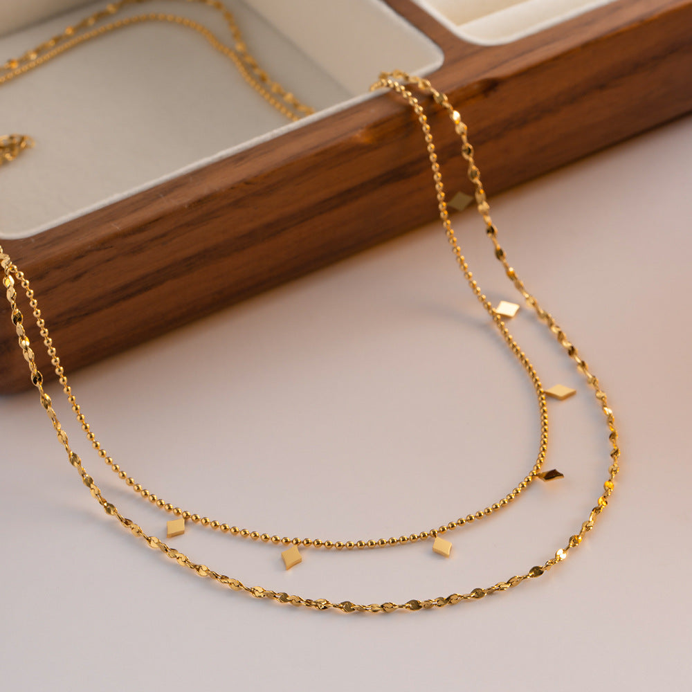 Double-layer tassel collarbone necklace in French style with elegant gold chains and dangling tassels, styled on a model.