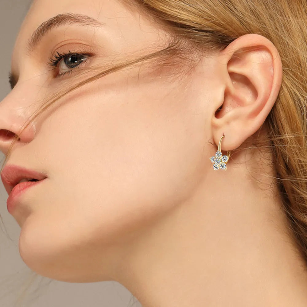 Sterling silver moissanite flower huggie earrings with 1.2 carat total weight, featuring intricate floral design and sparkling stones.